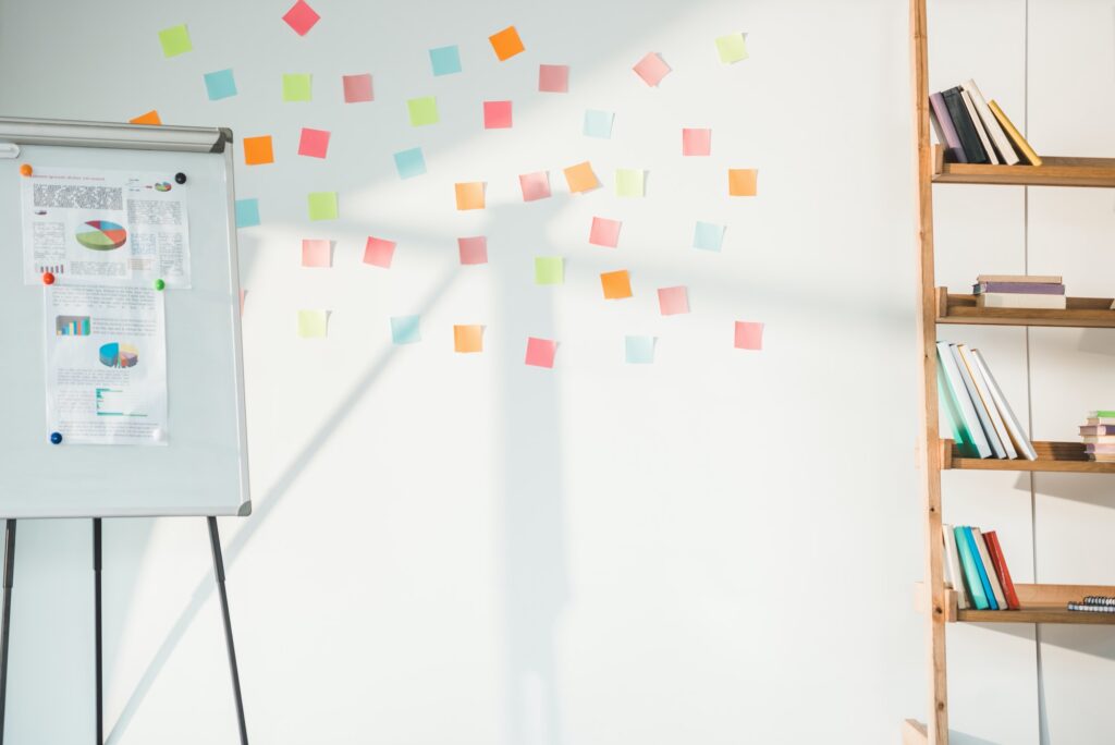 whiteboard with charts and white board with sticky notes in modern light office